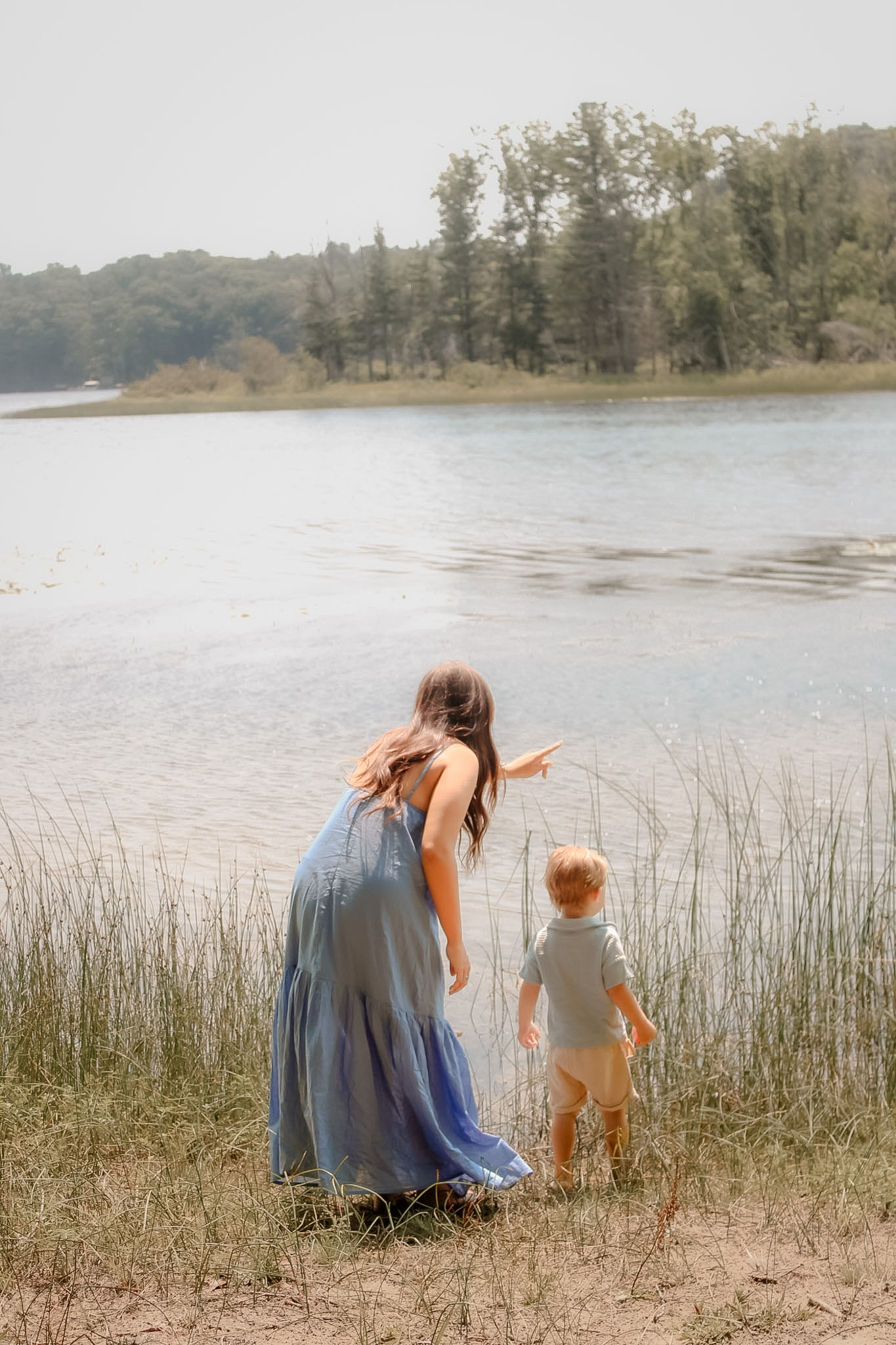 Mother and young child sharing a quiet moment beside the lake