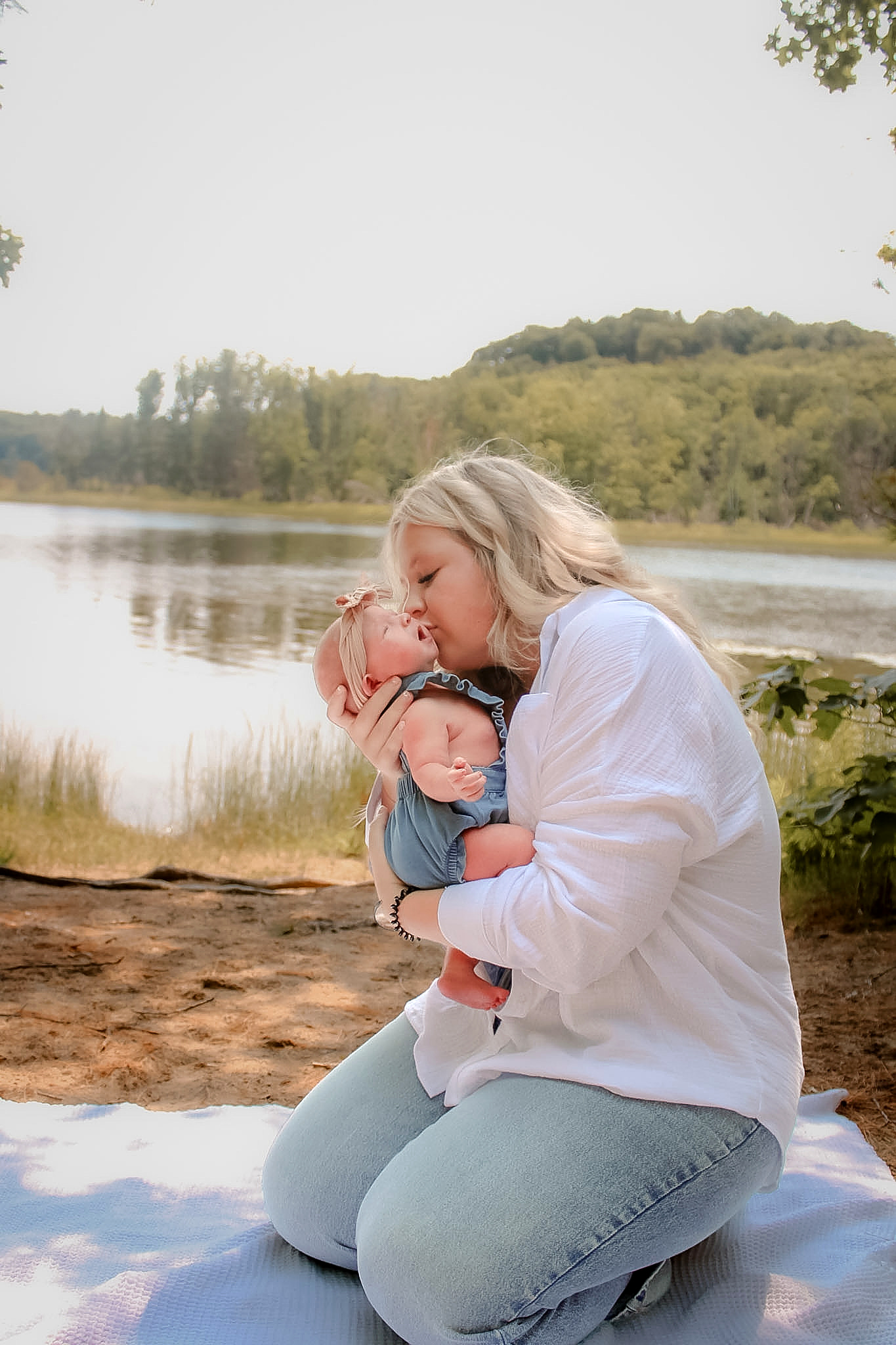 Mother holding her newborn beside the lake