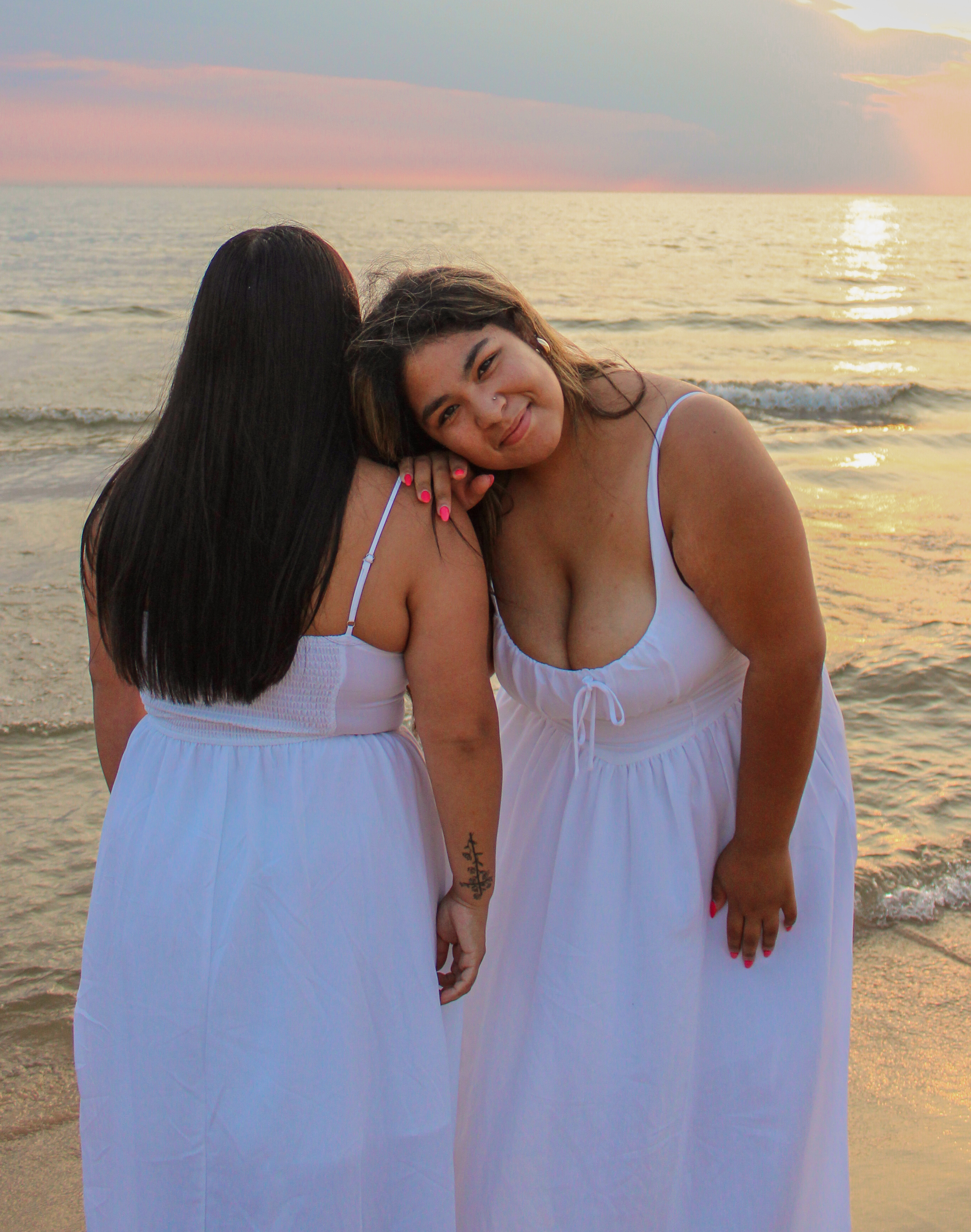 Two best friends sitting close together with one resting her head on the other's shoulder