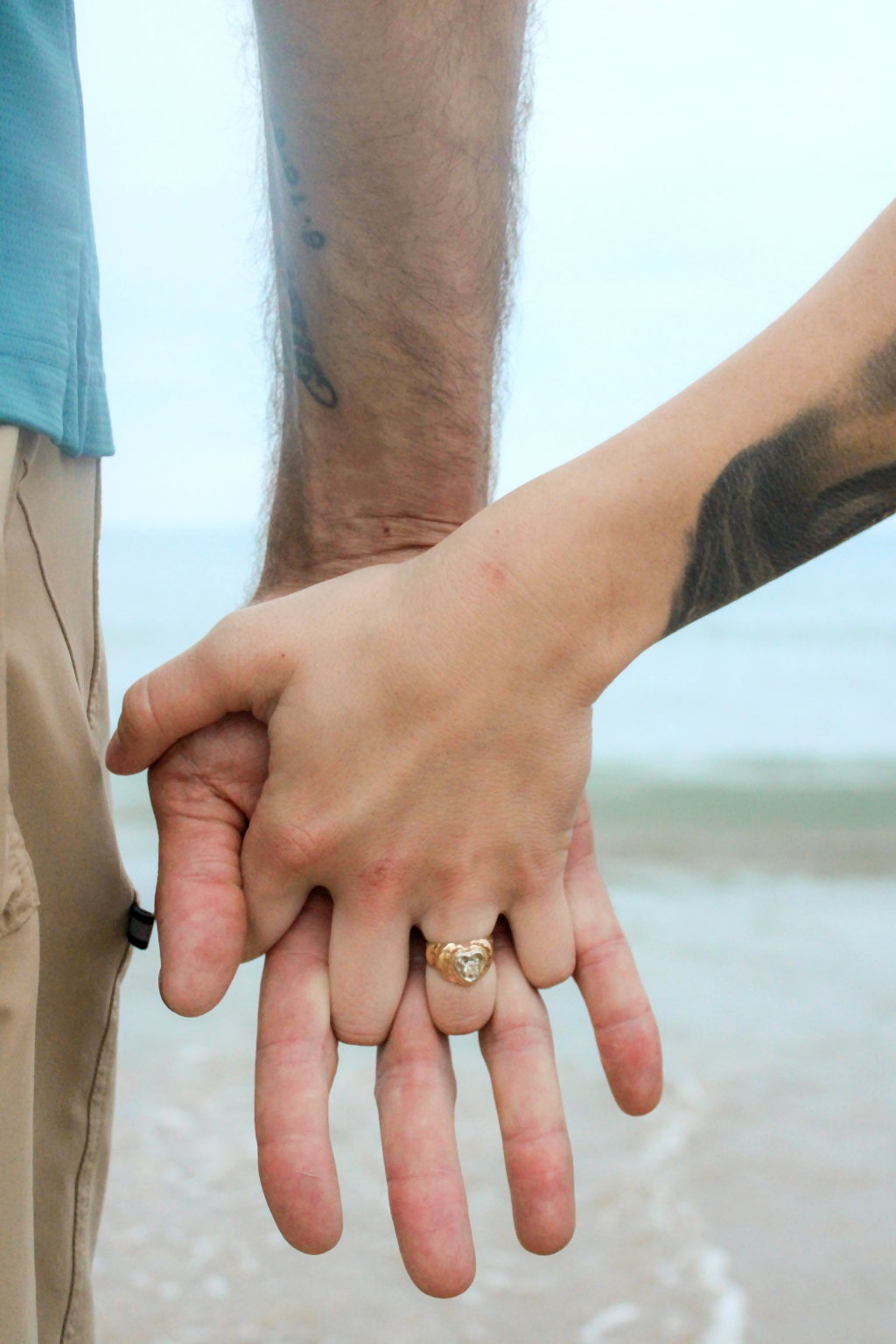 Couple holding hands with an engagement ring visible
