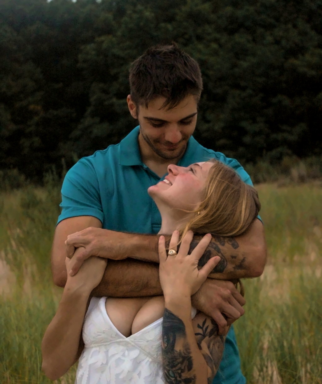 Couple smiling together in a grassy field