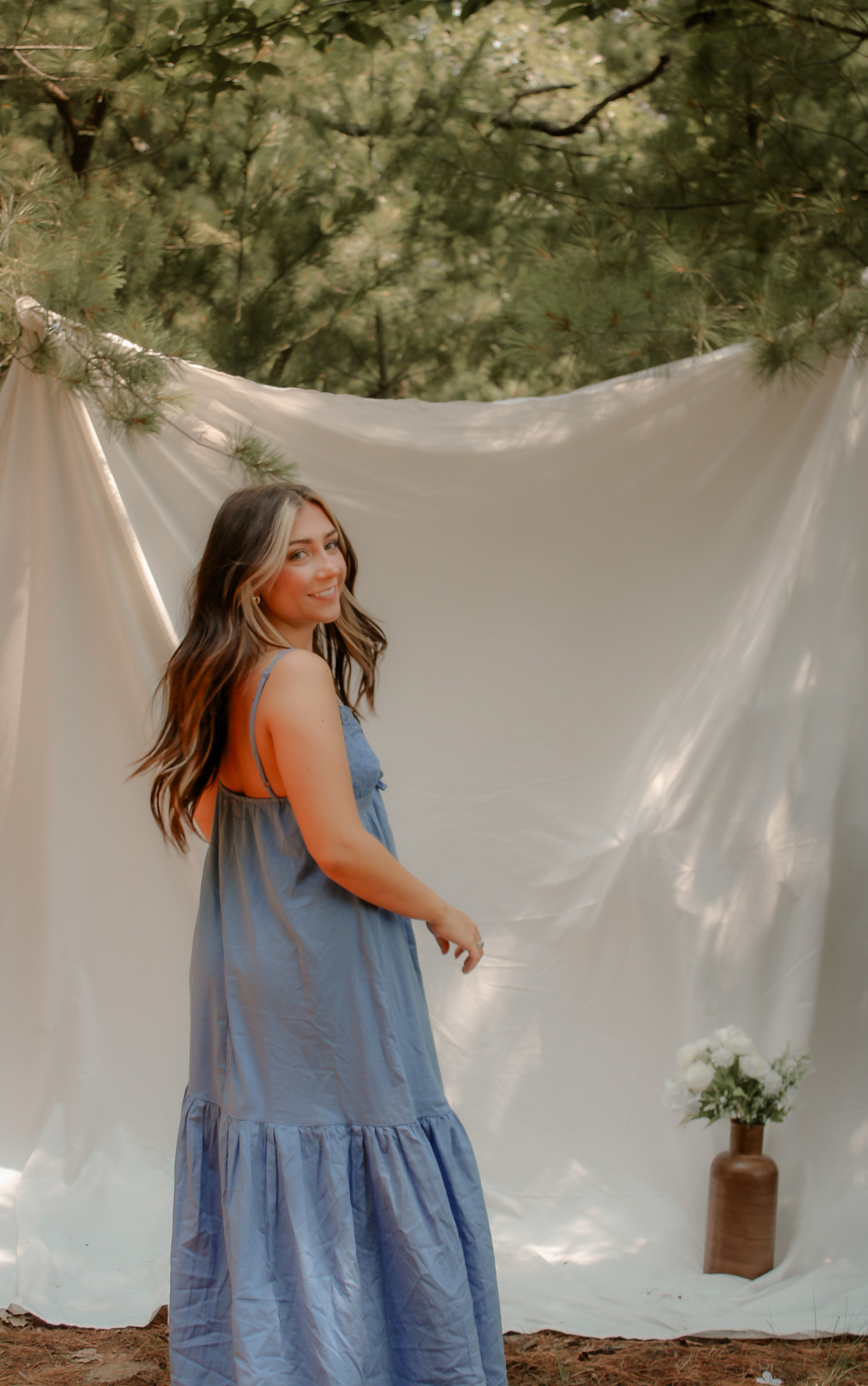 Outdoor portrait in a blue dress with a soft fabric backdrop
