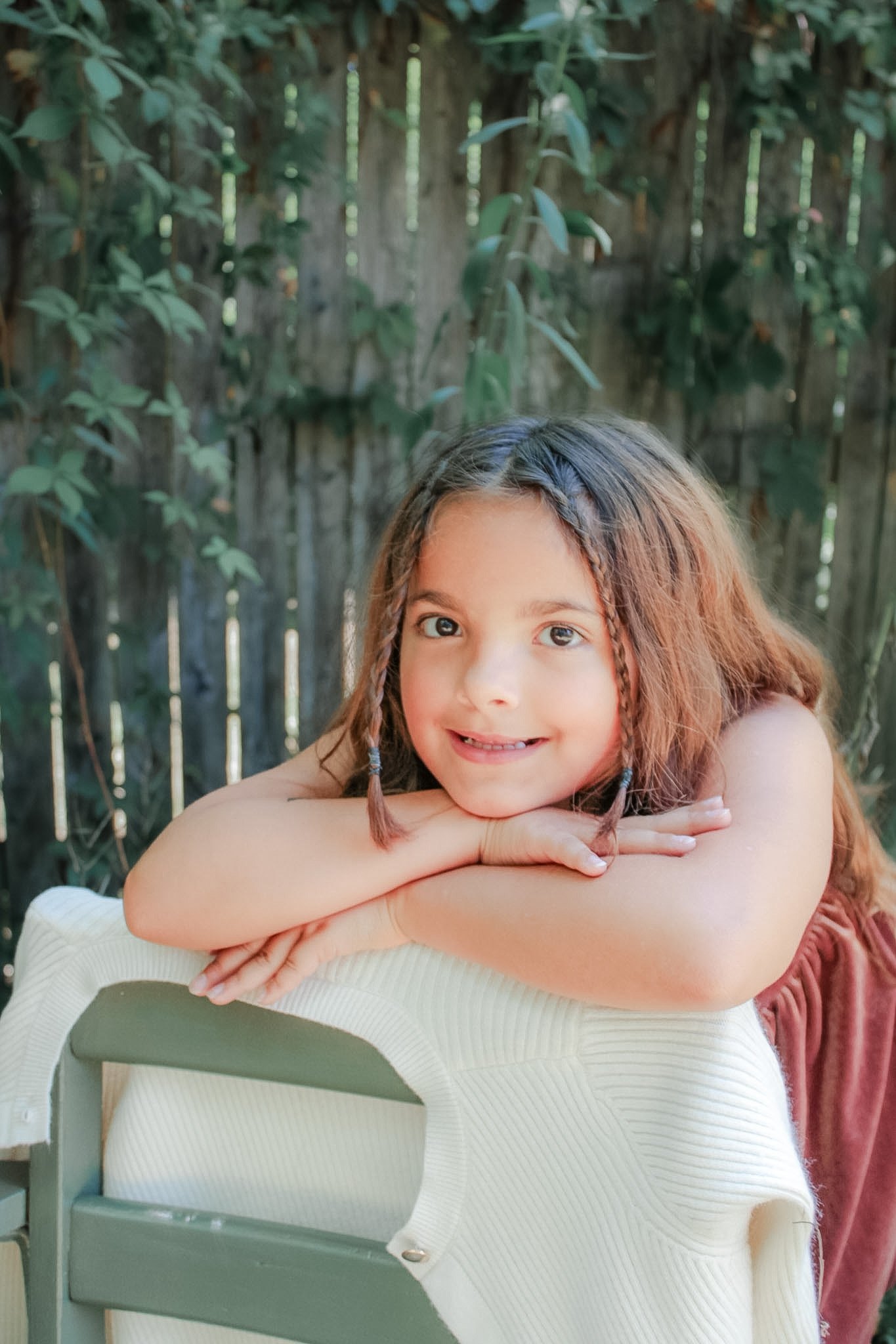 Young student smiling with her arms folded over a chair